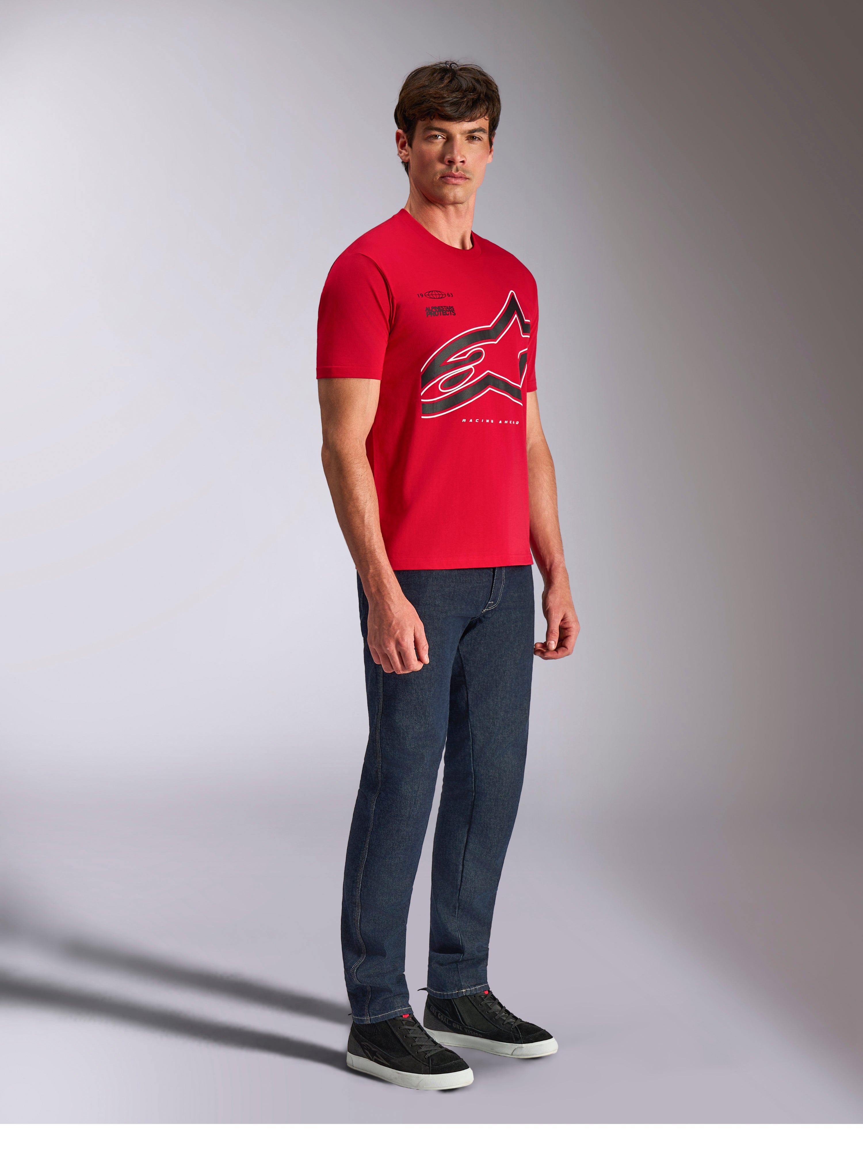 Alpinestars Authority CSF Tee, kurzärmeliges T-Shirt, Rot, großes, beschnittenes Astars-Logo mit schwarz-weißen Umrissen, getragen von einem Model mit dunkler Jeanshose und schwarzen Sneakern, lässige, vom Motorsport inspirierte Streetwear