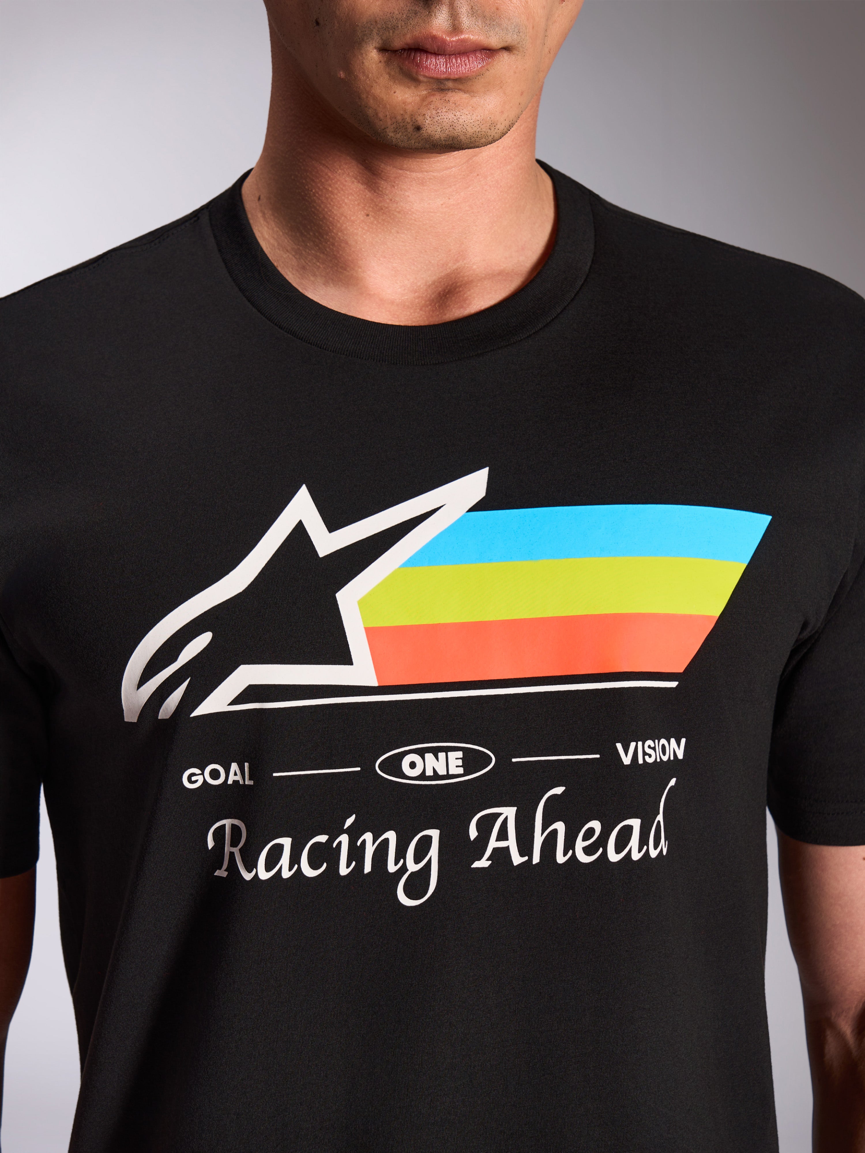 Alpinestars Trifecta CSF Tee, Short Sleeve T-Shirt, Black, close-up of front graphic with white Astars logo and tri-color blue green and orange stripes, 'Racing Ahead' text, casual motorsport streetwear