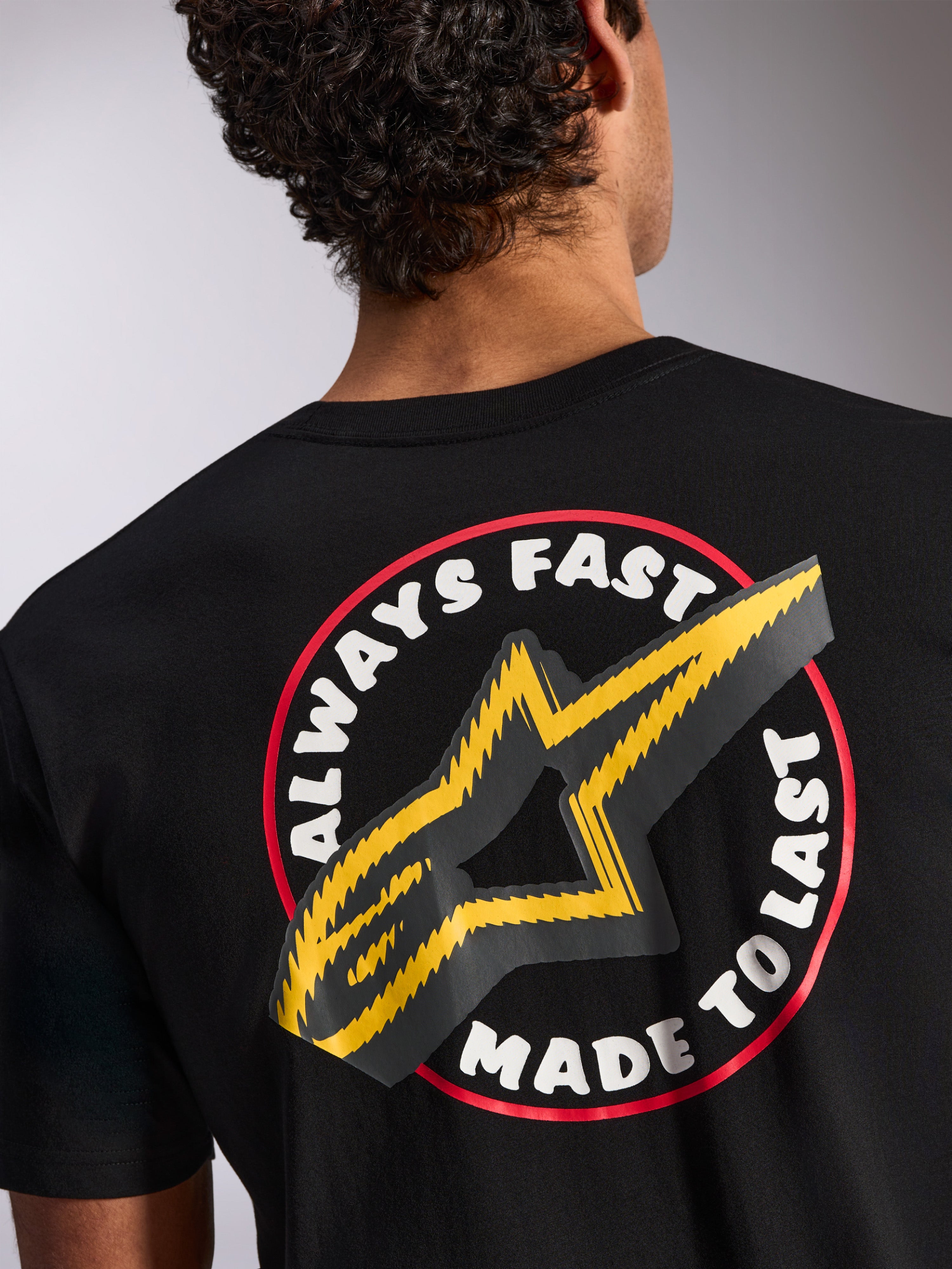Alpinestars Aorbit CSF Tee, Kurzarm-T-Shirt, Schwarz, Rückendetail mit „Always Fast Made to Last“-Grafik und gelbem Stern-Logo, lässige, vom Motorsport inspirierte Streetwear