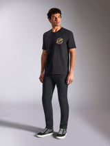 Alpinestars Aorbit CSF Tee, Short Sleeve T-Shirt, Black, featuring a circular Always Fast Made to Last graphic on the chest, worn by a model with dark slim pants and sneakers, casual motorsport streetwear