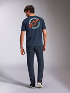 Alpinestars Aorbit CSF Tee, kurzärmeliges T-Shirt, Navy, Rückansicht am Modell mit großer kreisförmiger Grafik, rotem Astars-Logo und „Always Fast Made to Last“-Schriftzug, lässige Motorsport-Streetwear