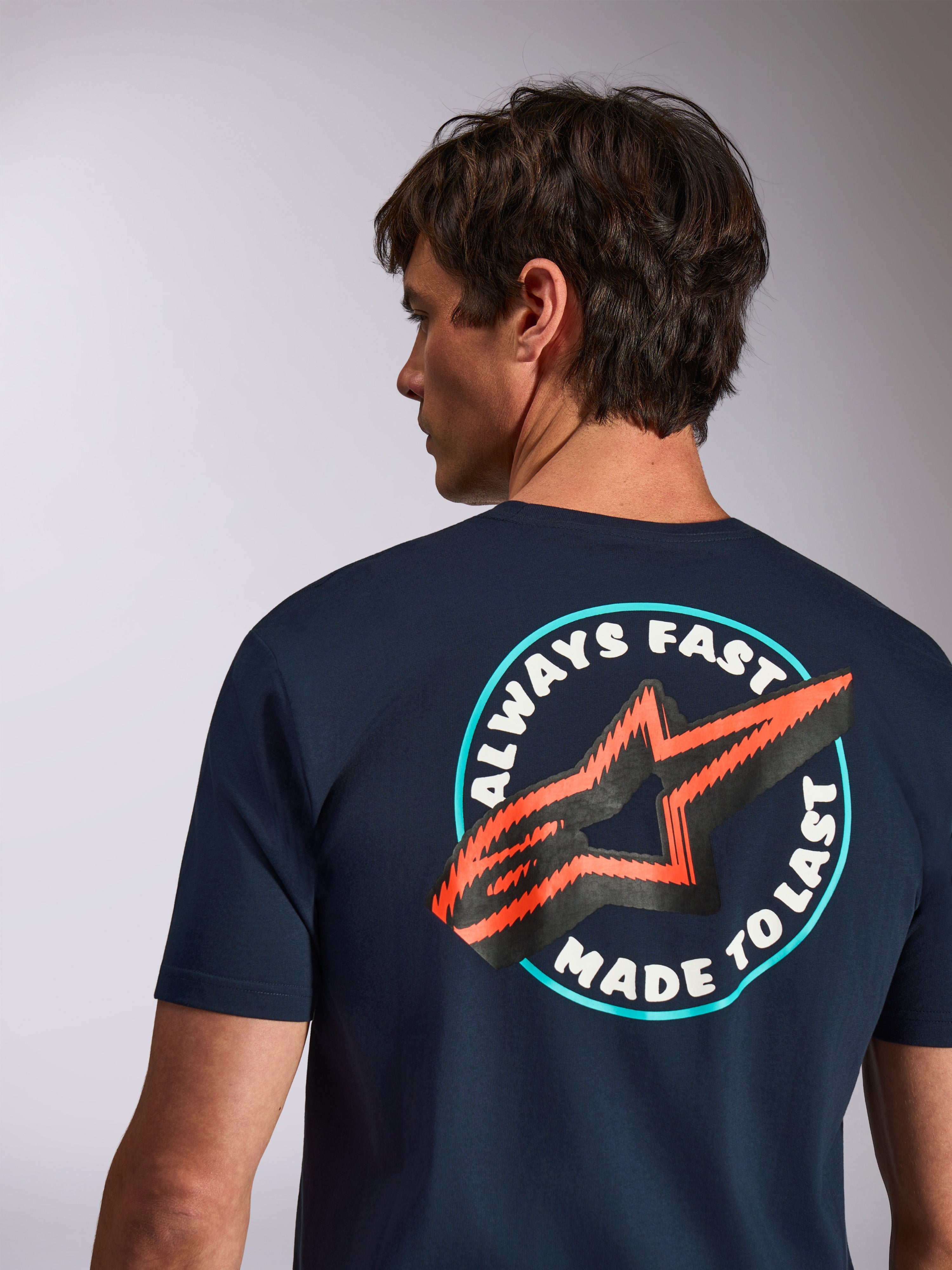 Alpinestars Aorbit CSF Tee, Kurzärmliges T-Shirt, Navy, Rückansicht mit „Always Fast Made to Last“-Grafik und orangefarbenem Stern-Logo, lässige Motorsport-Streetwear