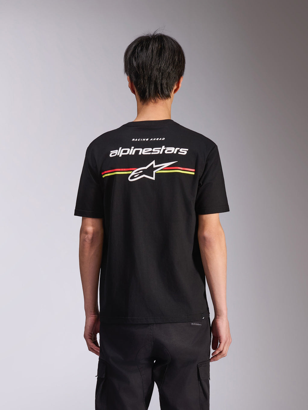 Alpinestars Lanes CSF Tee, Kurzarm-T-Shirt, Schwarz, Rückansicht mit weißem Alpinestars-Logo und Astars-Stern mit roten und gelben Streifen, Casual Motorsport Streetwear
