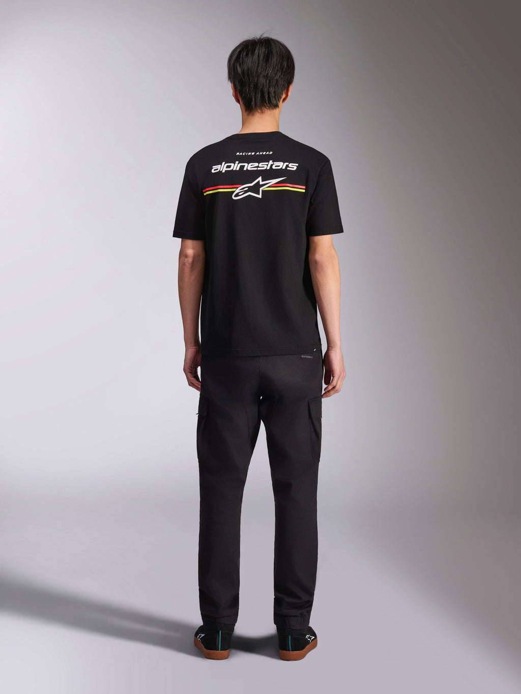 Alpinestars Lanes CSF Tee, Kurzarm-T-Shirt, Schwarz, Rückansicht mit weißem Alpinestars-Logo und roten und gelben Streifen, lässige Motorsport-Streetwear