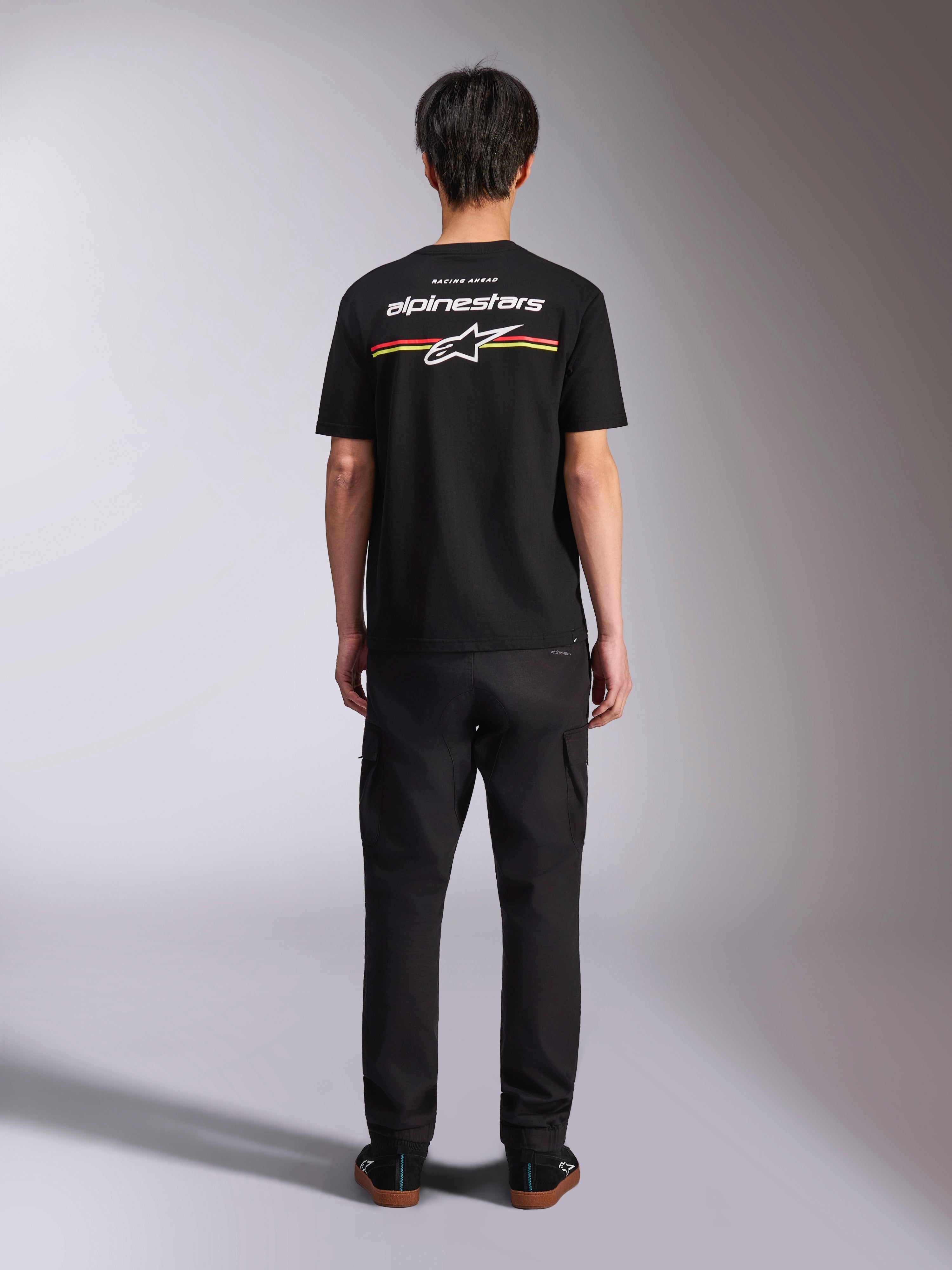 Alpinestars Lanes CSF Tee, Kurzarm-T-Shirt, Schwarz, Rückansicht mit weißem Alpinestars-Logo und roten und gelben Streifen, lässige Motorsport-Streetwear