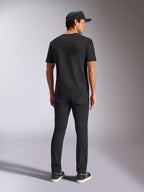 Alpinestars Verdure Camo CSF T-Shirt, Kurzarm-T-Shirt, Schwarz, Rückansicht, getragen mit schwarzer Hose und einer Mesh-Cap, lässige, vom Motorsport inspirierte Streetwear