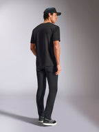 Alpinestars Verdure Camo CSF Tee, Kurzarm-T-Shirt, Schwarz, Rückansicht am Model mit schwarzer Hose und Trucker-Cap, lässige, vom Motorsport inspirierte Streetwear
