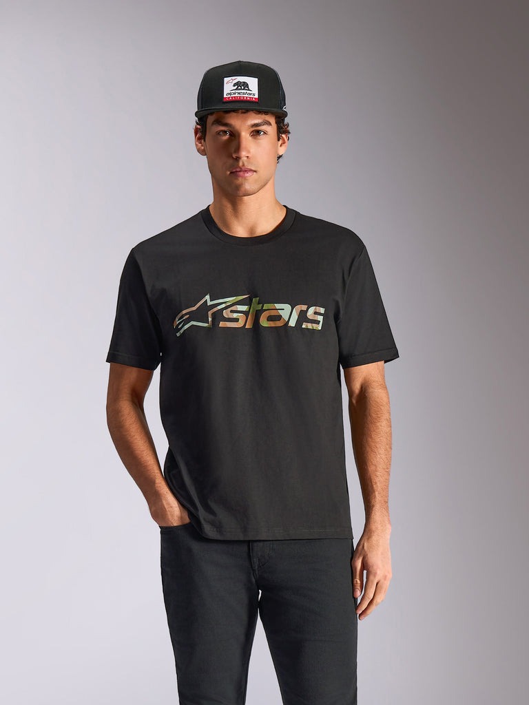Alpinestars Verdure Camo CSF Tee, Kurzarm-T-Shirt, Schwarz, getragen von einem Model mit schwarzer Cap und Hose, mit Astars-Logo in Camouflage-Füllung auf der Vorderseite, lässige Motorsport-Streetwear