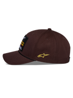 Alpinestars Matrix Snapback Mütze, Braun, Seitenansicht, gebogener Schirm mit schwarzem Kordeldetail, Front-Stickerei-Patch, gelbes seitliches Astars-Logo, strukturierte Baumwolltwill-Konstruktion, lässige Motorsport-Kopfbedeckung