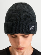 Alpinestars Unload Rib Cuff Mütze, Sportswear-Strickmütze in Anthrazitgrau, mit geripptem Umschlag und gewebtem Alpinestars Logo-Aufnäher, Nahaufnahme am Model