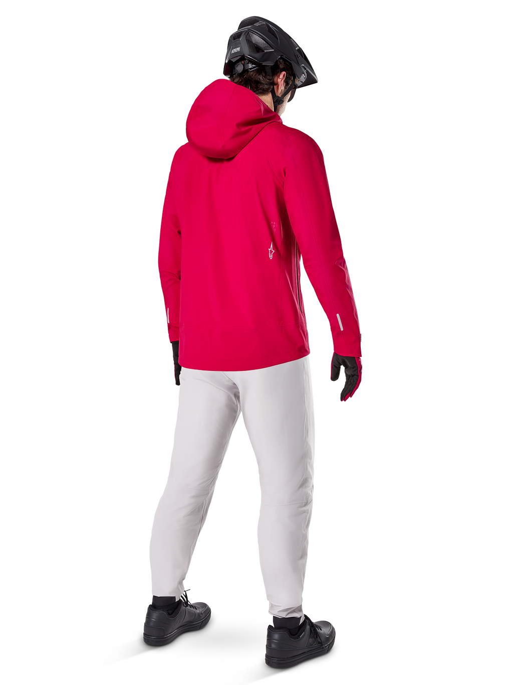 Alpinestars A-Dura Elite Wasserdichte Jacke, Red Fluo, Dreiviertel-Rückansicht, getragen mit hellgrauer Hose und schwarzem MTB-Helm, verfügt über eine Kapuze und reflektierende Akzente, Hochleistungs-Fahrrad-Regenjacke für Trailfahrten