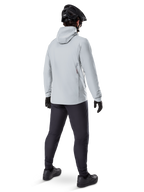 Alpinestars A-Dura Thermojacke in Titanium, Rückansicht eines männlichen Radfahrers in hellgrauer Thermojacke mit Kapuze, kombiniert mit schwarzem MTB-Helm, schwarzen Handschuhen und dunkelgrauer Hose, funktionelle Mountainbike-Ausrüstung