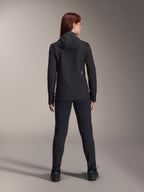 Alpinestars Stella A-Dura Thermal Jacke für Damen, Rückansicht, schwarze isolierte Fahrradjacke mit Kapuze, passende schwarze Hose und Schuhe, kleines weißes Logo auf dem unteren Rücken