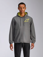 Alpinestars Speeder Chromium Windbreak Jacket, anthrazitgraue Windjacke mit Kapuze, neongelbes Stern-Logo, hellgrünes Kapuzenfutter, elastische Bündchen, verstellbare Kordelzüge, Frontreißverschluss, lässiger Motorsport-Stil