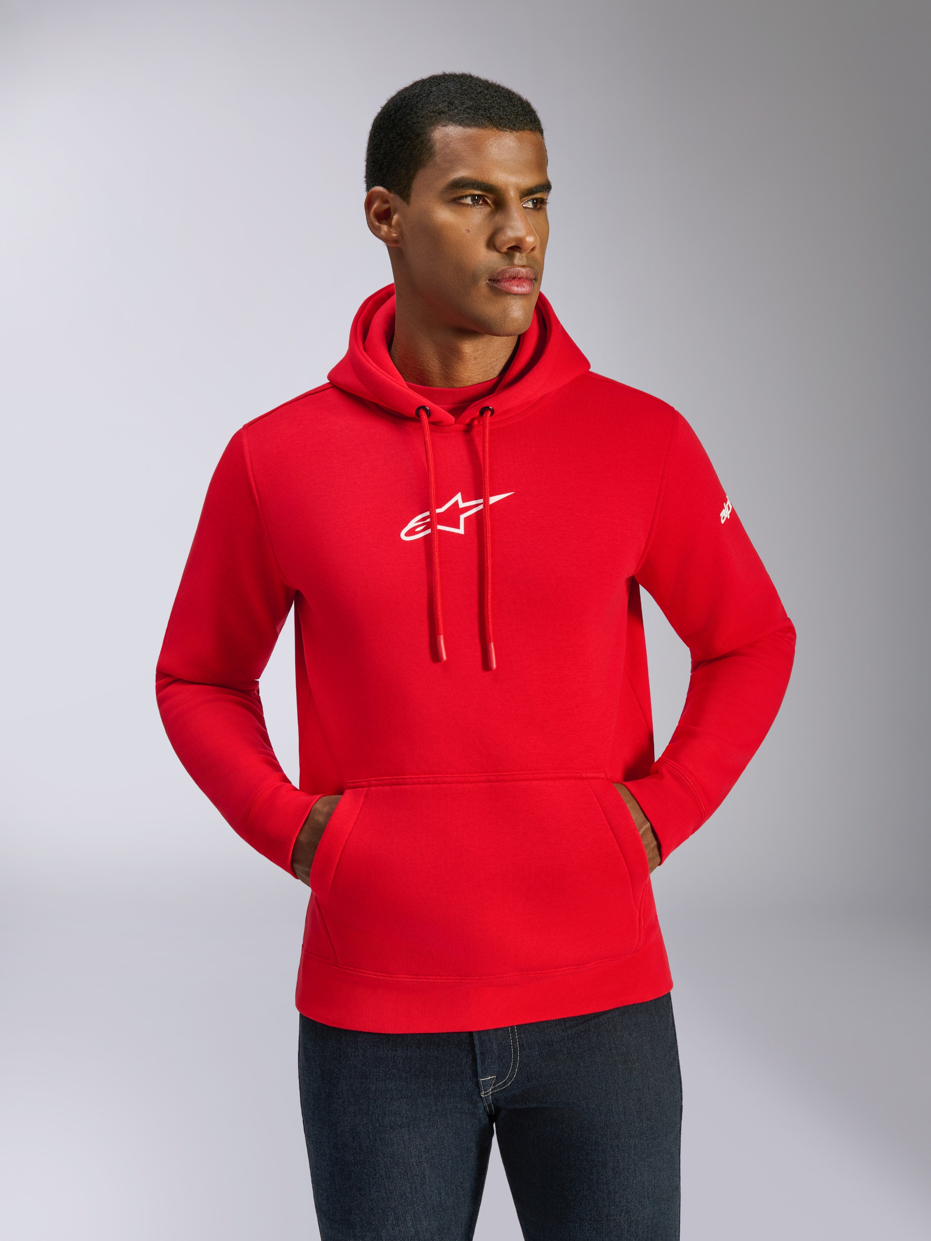 Alpinestars Frontal Hoodie, Rot mit weißem Logo, Männliches Model trägt Fleece-Kapuzenpullover mit Kängurutasche und verstellbarem Kordelzug, lässige Motorsport-Streetwear