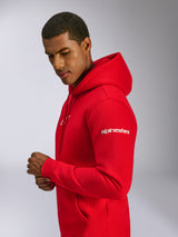 Alpinestars Frontal Hoodie, Rot, Pullover-Fleece-Hoodie, getragen von einem Model, mit weißem Alpinestars-Schriftzug am Ärmel, Frontlogo, Kängurutasche und Kapuze mit Kordelzug, lässiges, vom Motorsport inspiriertes Design