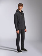 Alpinestars Frontal Hoodie, Schwarz, Fleece-Kapuzenpullover mit weißem HD-Logo auf der Brust und Wortmarken-Logos auf den Ärmeln, Kängurutasche, kombiniert mit schwarzer Hose und Sneakern, lässige vom Motorsport inspirierte Streetwear