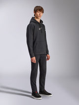 Alpinestars Frontal Hoodie, Schwarz, Fleece-Kapuzenpullover mit weißem HD-Logo auf der Brust und Wortmarken-Logos auf den Ärmeln, Kängurutasche, kombiniert mit schwarzer Hose und Sneakern, lässige vom Motorsport inspirierte Streetwear