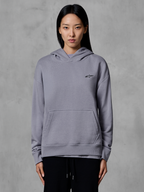 Alpinestars Essentials Ageless Hoodie, lässige Sportbekleidung, Silber mit kleinem schwarzem Logo, Kängurutasche, Kapuzenpullover, von einem Model getragen, moderne Lifestyle-Bekleidung