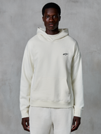 Alpinestars Essentials Ageless Hoodie, Off-White, getragen von einem männlichen Model, kleines schwarzes Logo auf der Brust, Kängurutasche vorne, lange Ärmel, lässige, vom Motorsport inspirierte Streetwear