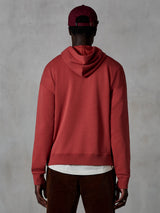 Alpinestars Essentials Ageless Hoodie, casual fleece hoodie, Brick red, back view of model wearing lifestyle apparel, featuring a clean design with ribbed hem and cuffs, styled with brown corduroy pants and a burgundy cap