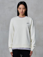 Alpinestars Essentials Ageless Crew, Rundhals-Sweatshirt, Off-White, mit einem kleinen schwarzen Alpinestars-Logo auf der Brust, lässige Lifestyle-Bekleidung, präsentiert an einer Frau