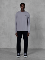 Alpinestars Essentials Ageless LS Tee, Langarm-T-Shirt, Silber, kleines schwarzes Alpinestars-Logo auf der Brust, Bio-Baumwolljersey mit Stone-Wash-Finish, getragen von einem Model mit schwarzer Hose und Sneakern, lässige Streetwear