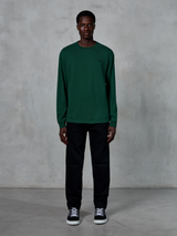 Alpinestars Essentials Ageless LS Tee, Long-Sleeve T-Shirt, Pine Green, featuring a small black logo on the chest, worn by a model with black pants and sneakers, casual streetwear style