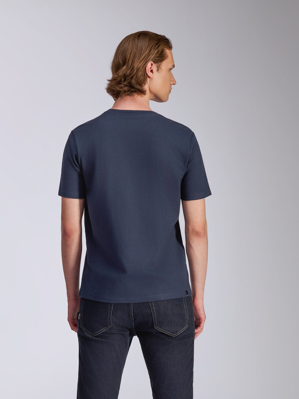 Alpinestars Fasting CSF T-Shirt, Kurzarm-T-Shirt, Marineblau, Rückansicht, von einem Model mit dunkler Jeans getragen, lässige, vom Motorsport inspirierte Streetwear