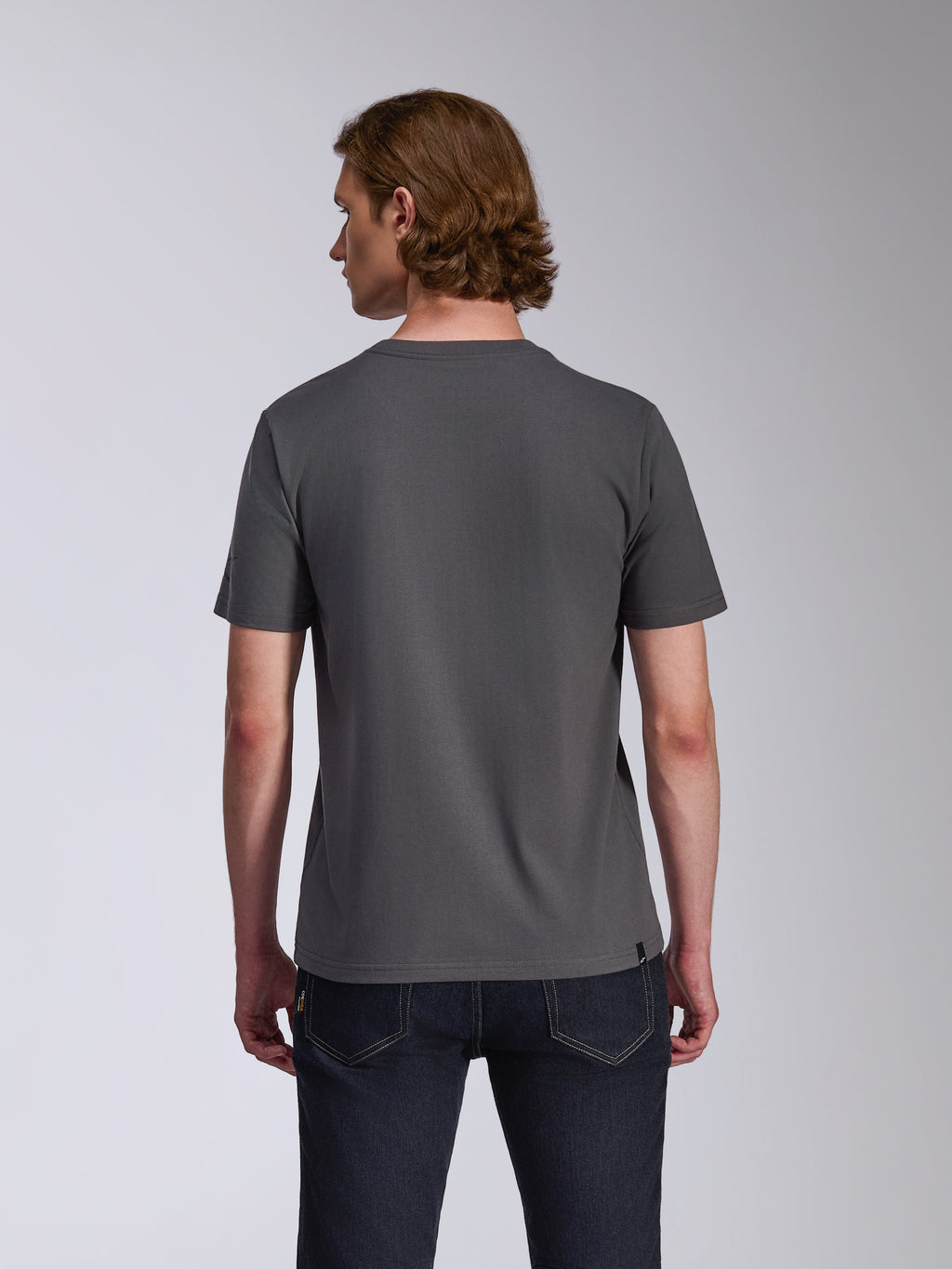 Alpinestars Waving CSF Tee, Kurzarm-T-Shirt, Anthrazitgrau, Rückansicht, getragen von einem Model mit dunkler Jeans, lässige Motorsport-Lifestyle-Bekleidung