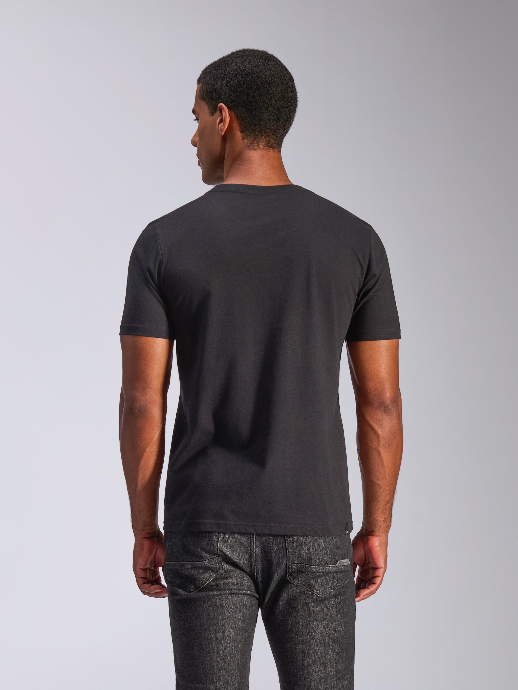 Alpinestars Tech Boot CSF Tee, Short Sleeve T-Shirt, Black, back view of a man wearing the tee with dark grey jeans, casual motorsport streetwear