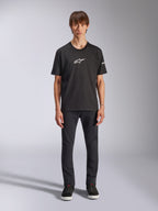 Alpinestars Frontal CSF T-Shirt, Kurzarm-T-Shirt, Schwarz, weißes Alpinestars-Logo auf der Brust, getragen von einem Model mit schwarzer Hose und schwarzen Schuhen, lässige Performance-Sportbekleidung