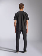 Alpinestars Frontal CSF T-Shirt, Kurzarm, Schwarz, Rückansicht am Model in schwarzen Jeans, lässige Performance-Streetwear mit kleinem weißem Logo-Detail am Ärmel