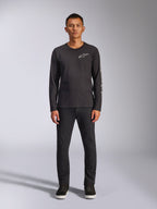 Alpinestars Trackside CSF Tee, Langarm-T-Shirt, Schwarz, weißes Alpinestars-Logo auf der Brust und grafisches Branding am Ärmel, getragen mit schwarzer Hose und Sneakern, lässige, vom Motorsport inspirierte Streetwear