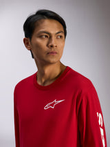Alpinestars Trackside CSF Tee, Langarmshirt, Rot mit weißem Alpinestars-Logo auf der Brust und Schriftzug am Ärmel, lässige Motorsport-Streetwear, Lifestyle-Porträt
