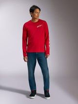 Alpinestars Trackside CSF Tee, Langarmshirt, Rot mit weißem Alpinestars-Logo, Lifestyle-Aufnahme getragen mit blauen Jeans und schwarzen Sneakern, lässige, vom Motorsport inspirierte Sportbekleidung