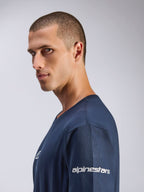 Alpinestars Frontal CSF Tee, Kurzarm-T-Shirt, Marineblau, Seitenprofil eines männlichen Models, weißes Alpinestars-Logo am Ärmel, feuchtigkeitsableitendes Funktionsgewebe, lässiger Motorsport-Lifestyle