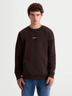 Alpinestars Guise Oversized Crew, brauner Fleece-Pullover für den Alltag, entspannte Oversized-Passform an Model gezeigt, Braun, Baumwolle und recyceltes Polyester, mit Kängurutasche und gesticktem Alpinestars-Logo auf der Brust und am Ärmel für einen vom Motorsport inspirierten Look.