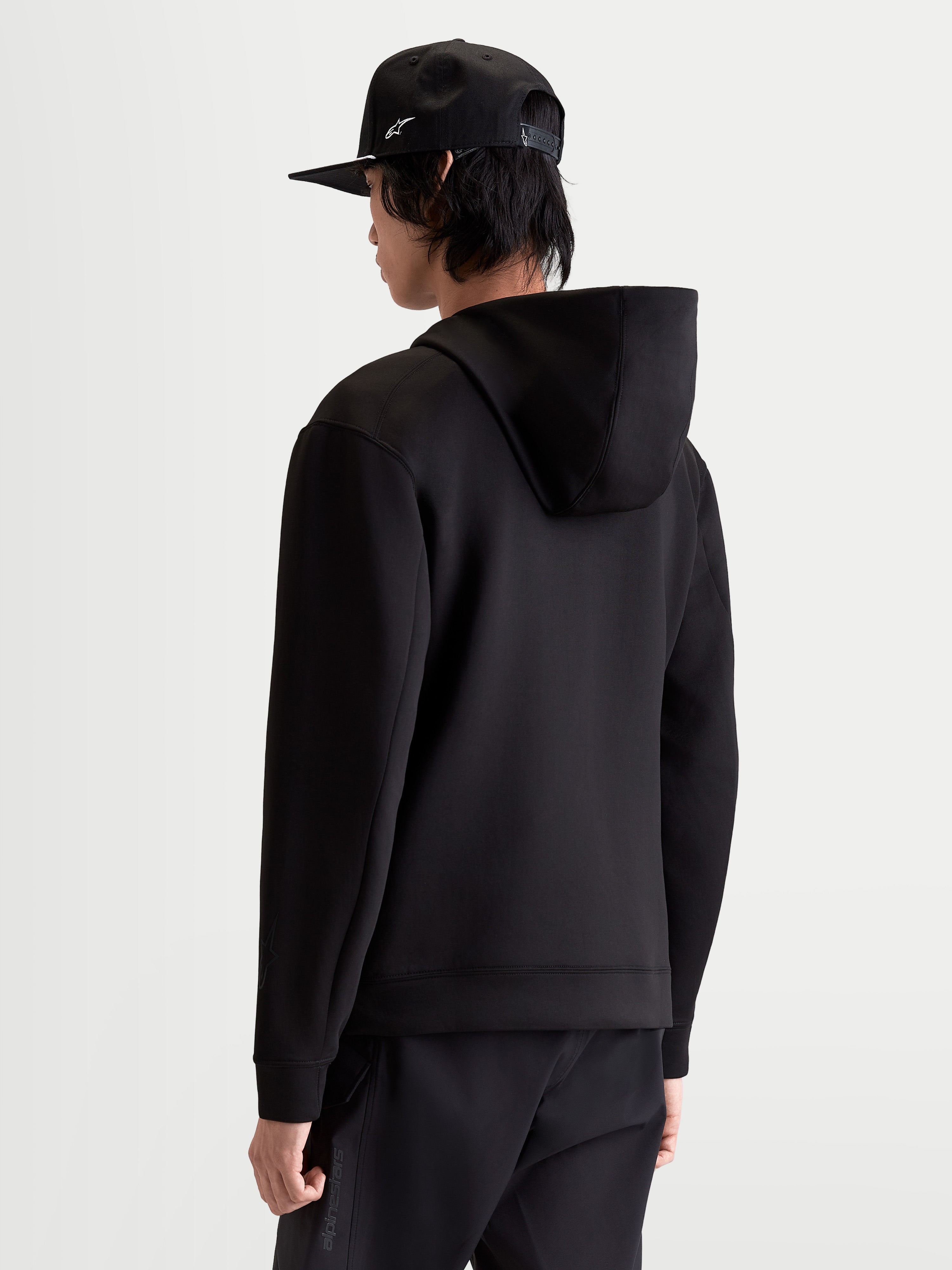 Alpinestars Datrix Hoodie, Herren-Sportswear-Pullover in Schwarz, Rückansicht am Modell mit Double-Face-Fleece-Konstruktion und mesh-gefütterter Kapuze für lässigen Komfort und einen motorsport-inspirierten Stil.