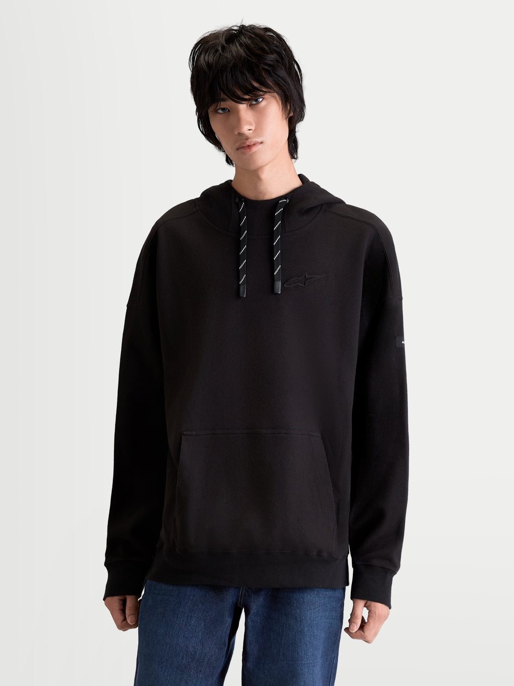 Alpinestars Camino Textured Oversized Hoodie, Sportswear Lifestyle Pullover, Unisex, Schwarz, aus strukturiertem Stricktwill-Fleece, mit hohem Kragen, Kängurutasche und tonaler Astars-Stickerei auf der Brust.