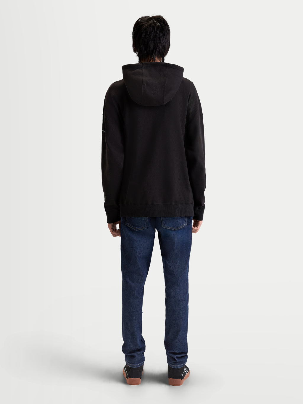 Alpinestars Camino Textured Oversized Hoodie, Lifestyle-Sportswear-Kapuzenpullover, Schwarz, Rückansicht am Modell, strukturiertes Stricktwill-Fleece, entspannte Oversize-Passform für hohen Alltagskomfort.