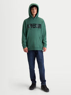 Alpinestars Shaw Oversized Hoodie, Relaxed Sportswear Pullover for Everyday Comfort, Green with Black Textured Word Logo, On-Model Front View, Soft Fleece Cotton and Recycled Polyester Blend, featuring a Kangaroo Pocket and Ribbed Trims.