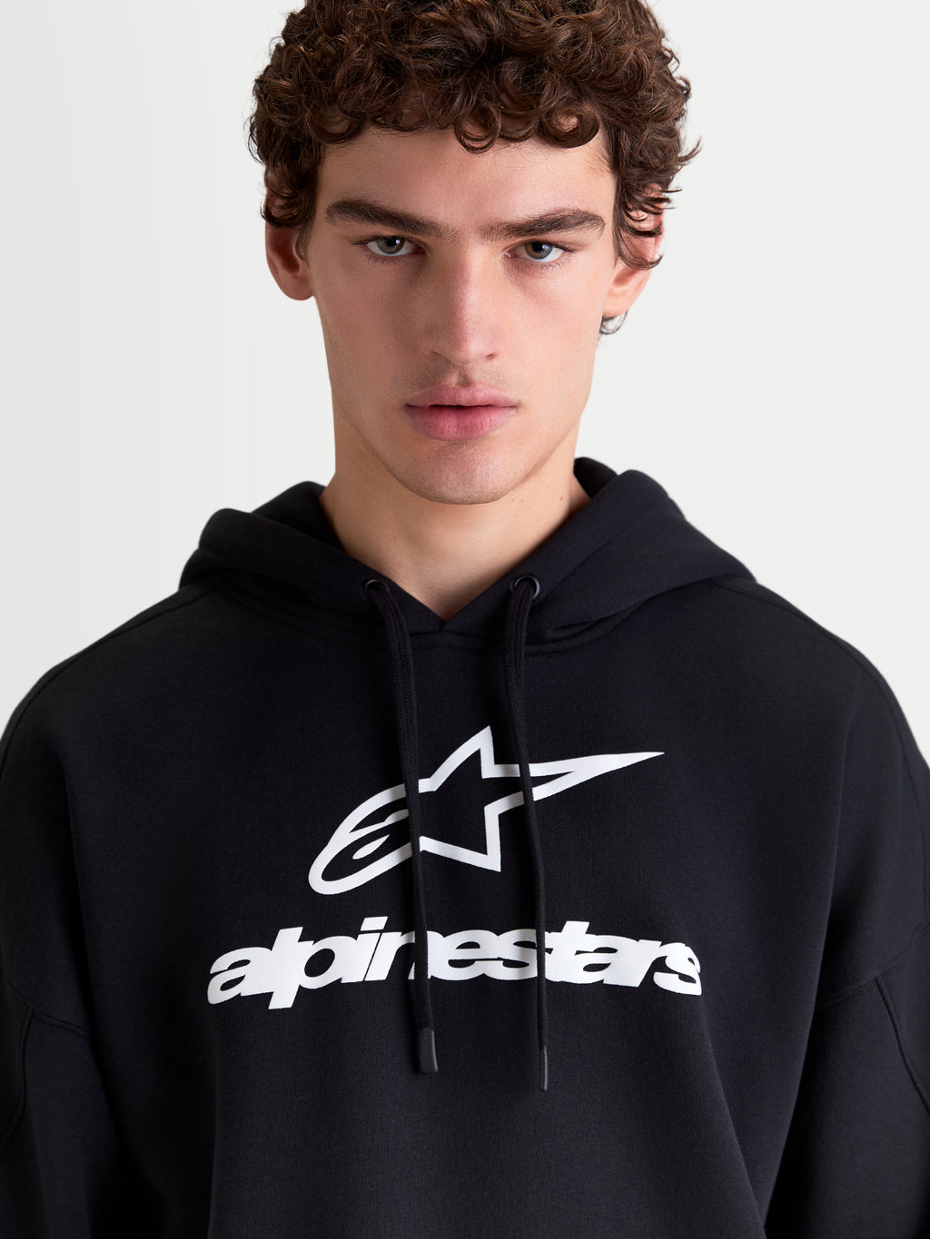 Alpinestars Prelude Oversized Hoodie, Sportswear Fleece-Pullover, Schwarz und Weiß, mit markantem Puff-Print-Logo auf der Brust, selbstgefütterter Kapuze mit flachem Kordelzug und entspannter Oversized-Passform für täglichen Komfort.