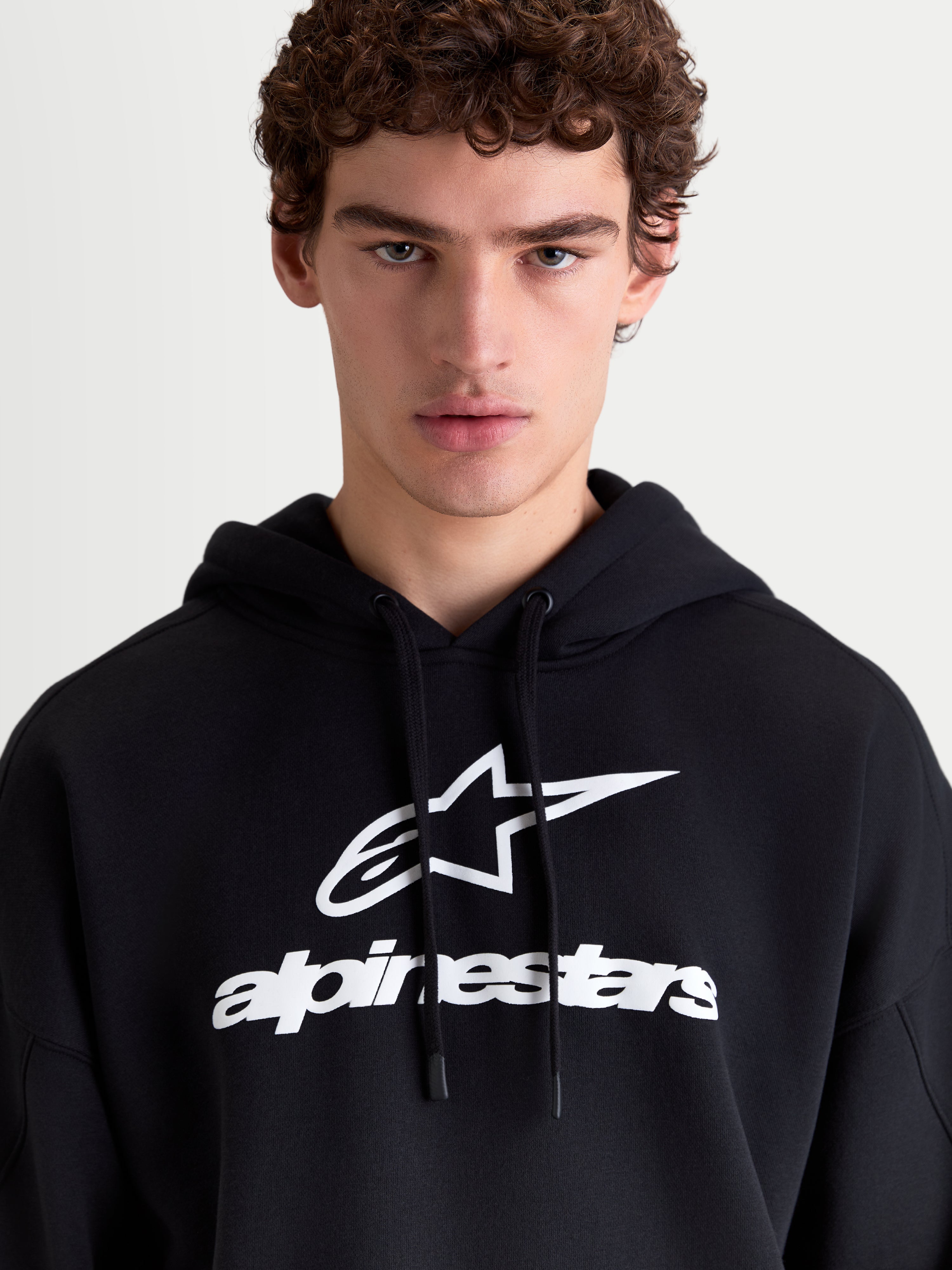 Alpinestars Prelude Oversized Hoodie, Sportswear Fleece-Pullover, Schwarz und Weiß, mit markantem Puff-Print-Logo auf der Brust, selbstgefütterter Kapuze mit flachem Kordelzug und entspannter Oversized-Passform für täglichen Komfort.