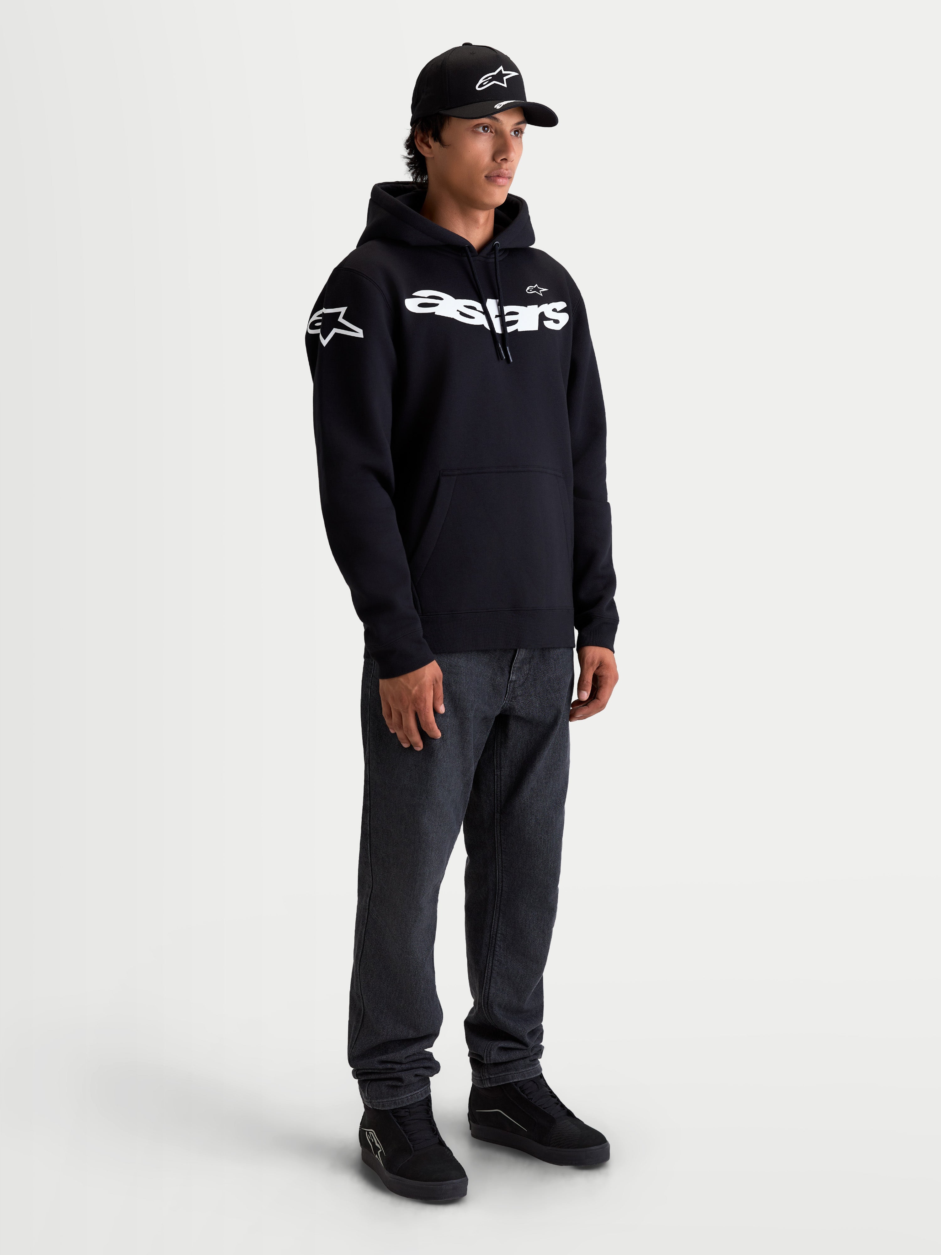 Alpinestars Velocifier Hoodie, Herren-Kapuzenpullover aus Fleece, Schwarz und Weiß, mit geschwungenem Astars-Schriftzug auf der Brust und Logos auf den Schultern, bequemer Sportswear-Stil für Motorsport-Fans abseits der Rennstrecke, Premium-Baumwollmischung.