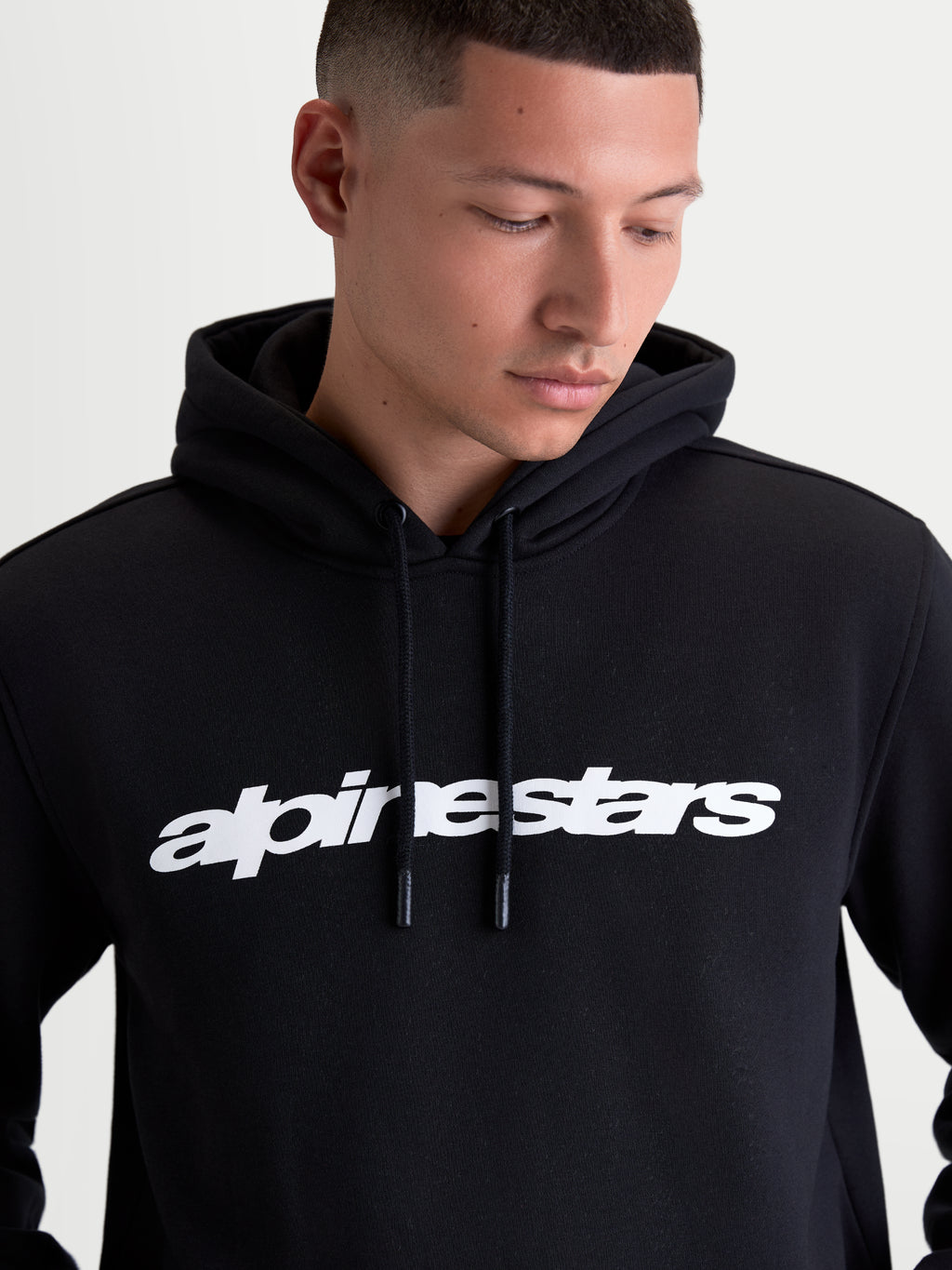 Alpinestars Race Wordmark Hoodie, Sportswear-Kapuzenpullover aus Fleece für Herren, Schwarz und Weiß, markanter Logo-Schriftzug auf der Brust, Kapuze mit Kordelzug und Kordelenden mit Tauchspitze, hochwertige Materialkonstruktion aus Baumwolle und recyceltem Polyester.