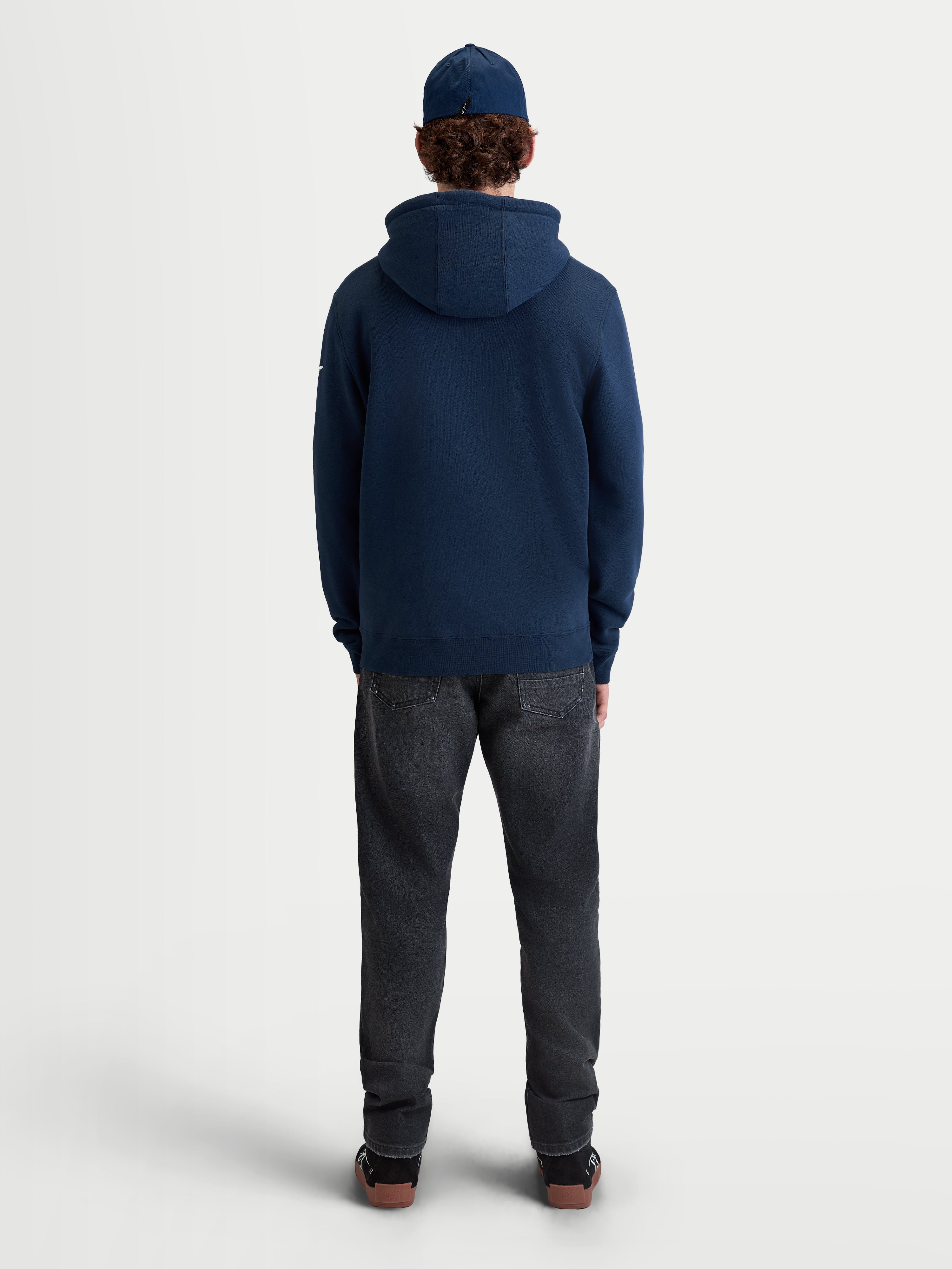 Alpinestars Race Wordmark Hoodie, Sportswear-Kapuzenpullover aus Fleece für den Alltag, Rückansicht am Modell, Blau, gefertigt aus einer weichen Mischung aus Baumwolle und recyceltem Polyester mit einer Kapuze aus Eigenmaterial und geripptem Saum.