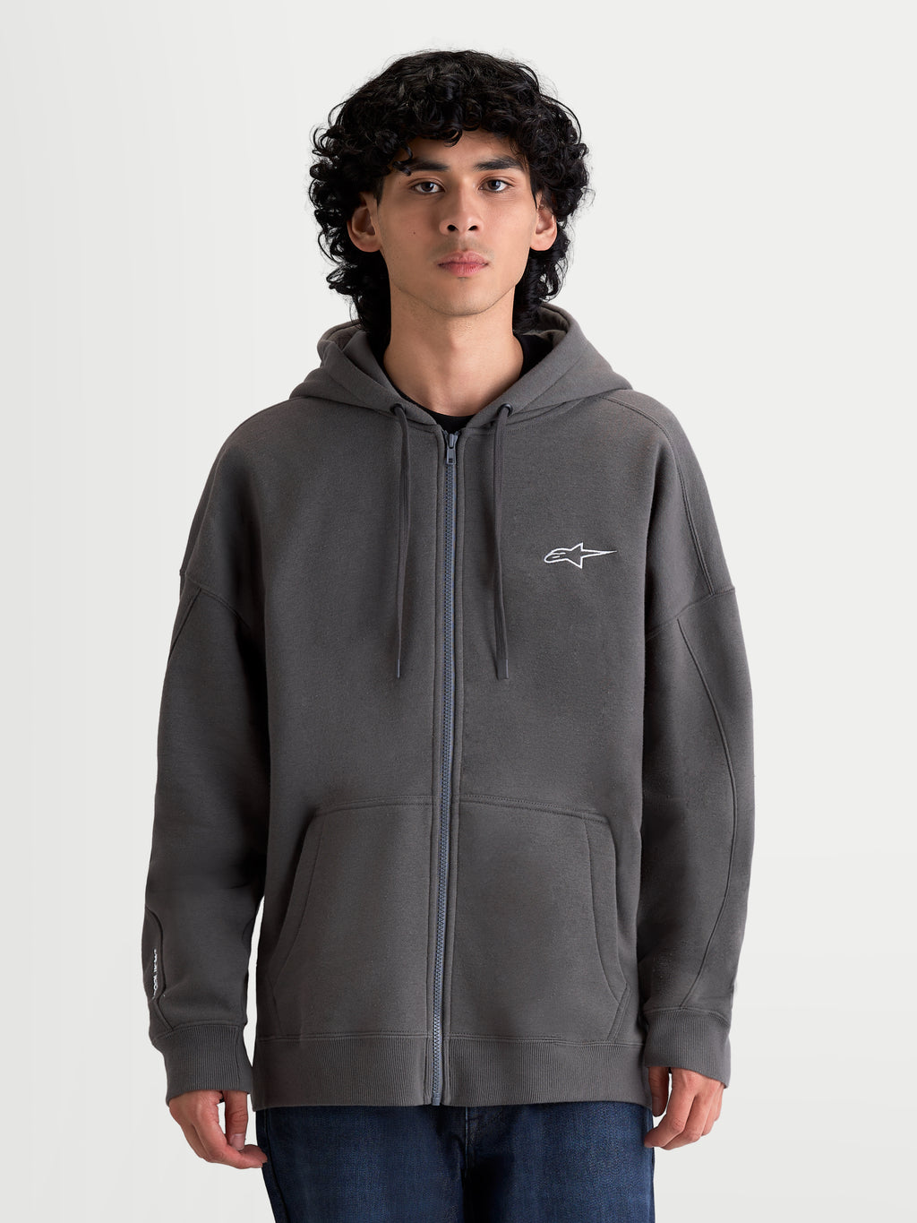 Alpinestars Entity Oversized Hoodie, Sportswear-Kapuzenjacke in Grau, Fleece-Mix aus Baumwolle und recyceltem Polyester, Vislon-Reißverschluss, Astars-Logo-Stickerei und entspannte Oversized-Passform am Modell.