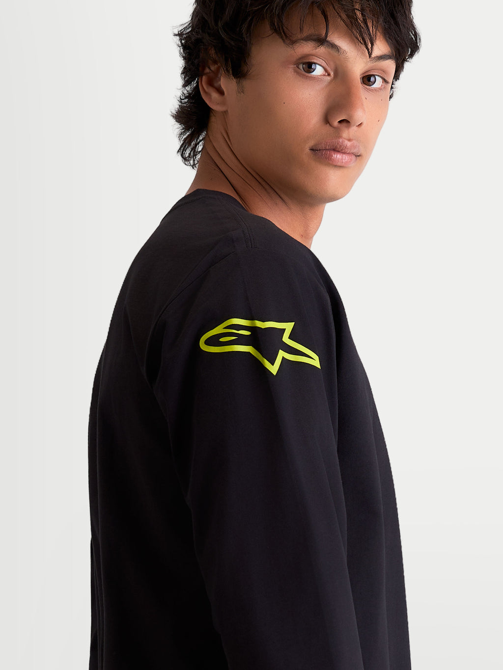 Alpinestars Velocifier CSF T-Shirt, Herren Langarm-T-Shirt, Schwarz mit leuchtend gelbem Astars-Logo auf der Schulter, Nahaufnahme am Model, Motorsport-Sportswear.
