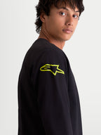 Alpinestars Velocifier CSF T-Shirt, Herren Langarm-T-Shirt, Schwarz mit leuchtend gelbem Astars-Logo auf der Schulter, Nahaufnahme am Model, Motorsport-Sportswear.